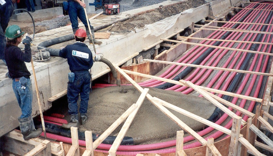 Fluidized Thermal Backfill being poured over red and black cable conduits
